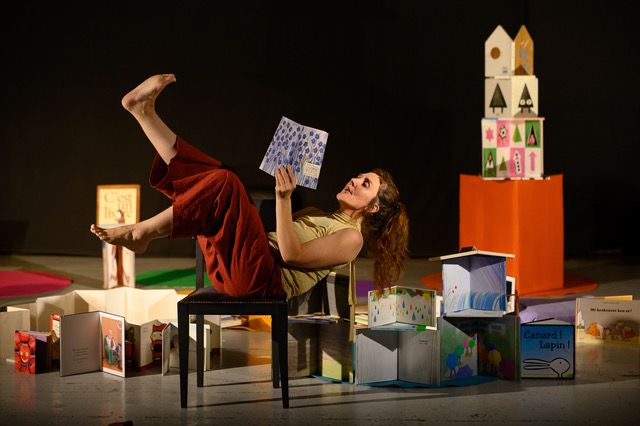 Une femme allongée sur une chaise lit un livre à voix haute.