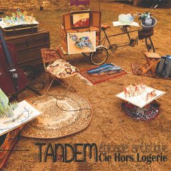 Affiche "Tandem épicerie artistique" extérieur d'une bâtisse où sont disposés des meubles anciens et des instruments de musique.