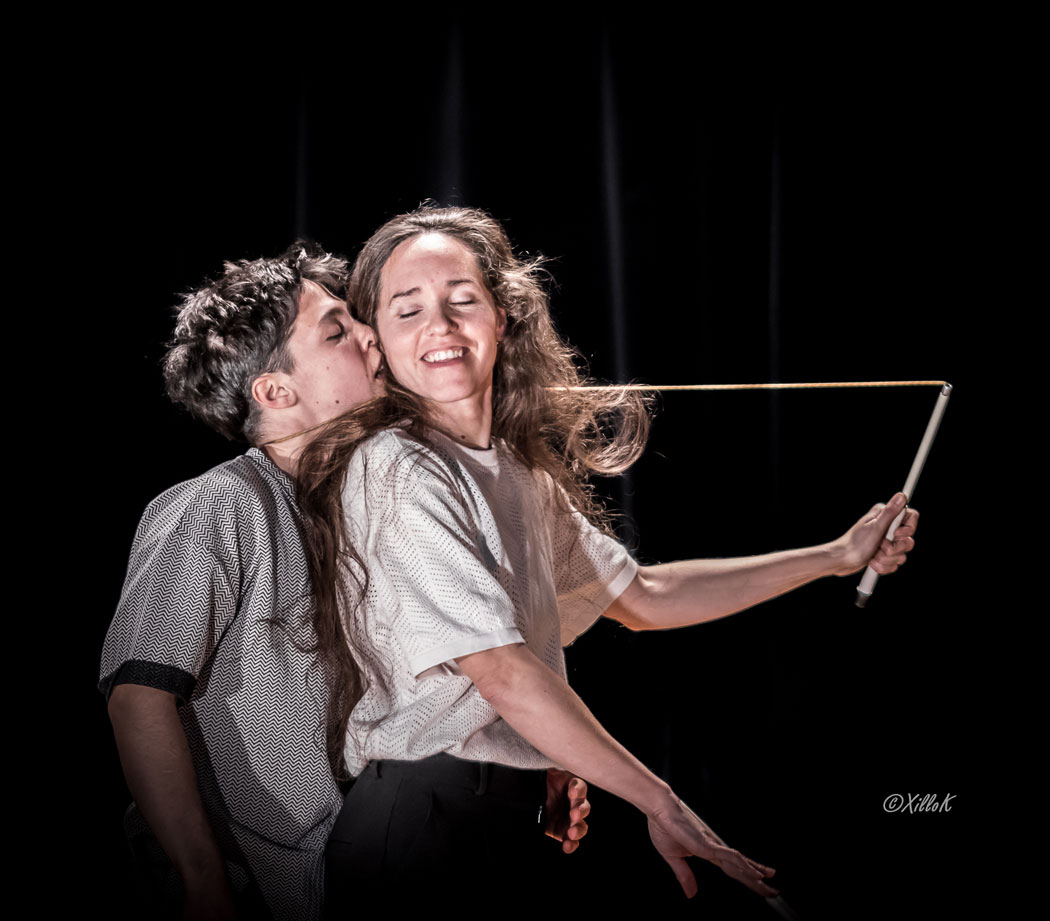 Photo du spectacle. En salle, sur scène.
Les  circassiens s'enlacent. On leur tendresse et leurs sourires remplacent les mots.
Une corde de diabolo reste présente autour d'eux pour exprimer leur lien et les actions de chacun sur la relation.