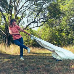 Une danseuse traine un sac dans la campagne, le tout formant des lignes de fuites.