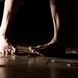 Gros plan sur des pieds nus qui marchent sur du verre.