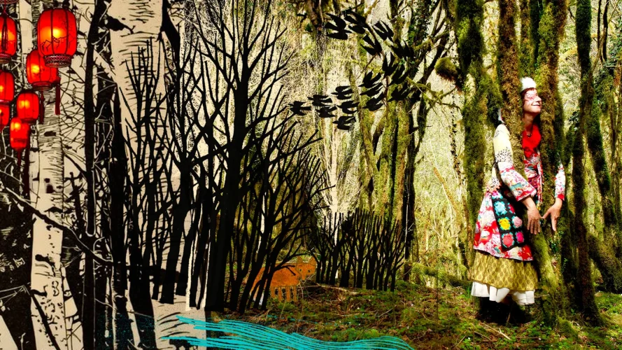 Une comédienne habillée avec des habits colorés, se tient devant un décor de forêt fait en photo et papier.